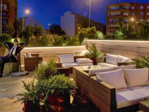 a rooftop patio with couches and tables and plants at Ibis Styles Figueres Ronda in Figueres