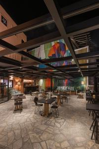 a room with tables and chairs and a colorful mural at Papi Boutique Hotel in Vathí