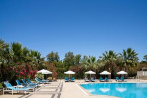 a pool at a resort with chairs and umbrellas at Ladonia Hotels Zemda in Gümüşlük +13 photos