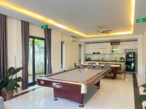 a living room with a pool table and a kitchen at FLC Grand Villa BT31-26 in Sầm Sơn