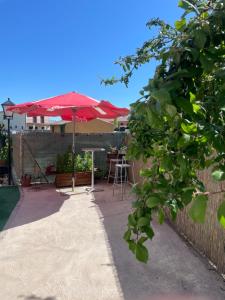a patio with a table and a red umbrella at Casa Mario in El Fresno