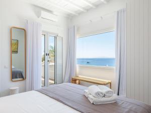 a bedroom with a bed with a view of the ocean at myMykonos villa II in Platis Gialos +56 photos