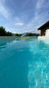 a swimming pool with blue water in front of a building at Orto del pettirosso Appartamento con piscina privata e BBQ in Front
