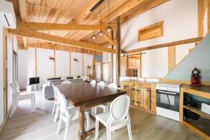 a kitchen and dining room with a wooden table and chairs at Le Mûrier - Grospierres in Grospierres