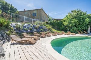 a row of chairs sitting next to a swimming pool at Le Mûrier - Grospierres in Grospierres