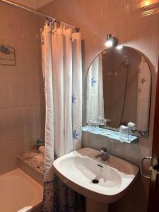a bathroom with a sink and a tub and a mirror at Hotel Apolo XI in Tahivilla