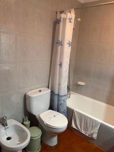 a bathroom with a toilet and a tub and a sink at Hotel Apolo XI in Tahivilla