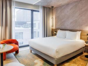 a hotel room with a bed and a large window at Novotel Tallinn in Tallinn