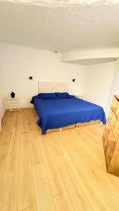 a bedroom with a blue bed and a wooden floor at Posada PuntaDelEste in Punta del Este