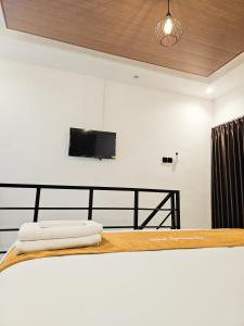 a bedroom with a bed with a flat screen tv on the wall at Lodjisvarga Villa Yogyakarta in Sleman