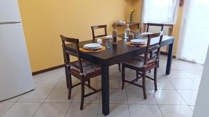 a dining room table with chairs and a black table with plates at Dimora Euganea by Ca-Sa Check in Monselice