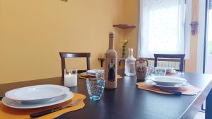 a dining room table with plates and bottles of wine at Dimora Euganea by Ca-Sa Check in Monselice