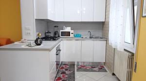 a kitchen with white cabinets and a microwave at Dimora Euganea by Ca-Sa Check in Monselice