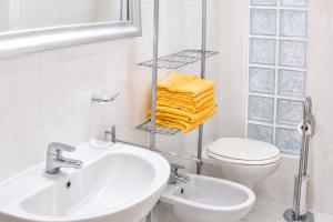 a white bathroom with a sink and a toilet at Trebbiano Rubicone in Gravedona +18 photos