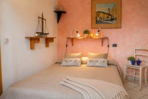 a bedroom with a bed in a room with pink walls at Trebbiano Rubicone in Gravedona