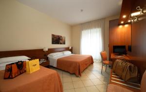 a hotel room with two beds and a television at Hotel Priscilla in Rome
