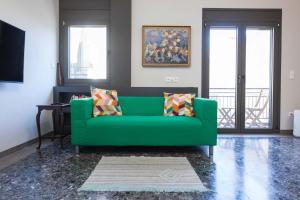 a green couch in a living room with a window at Brand-New Spacious 3 Bd Apt in Piraeus in Piraeus