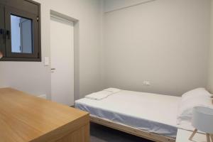 a small bedroom with a bed and a mirror at Brand-New Spacious 3 Bd Apt in Piraeus in Piraeus
