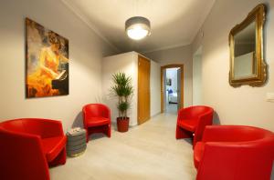 a waiting room with red chairs and a painting at Hotel Priscilla in Rome
