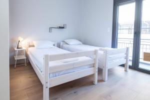 two white bunk beds in a room with a window at Brand-New Spacious 3 Bd Apt in Piraeus in Piraeus