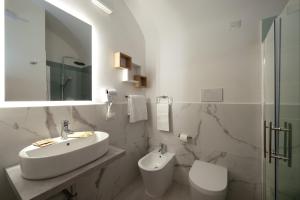 a white bathroom with a sink and a toilet at Hotel Priscilla in Rome