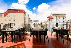 a patio with tables and chairs on a balcony at Jade Boutique Hotel in Hanoi