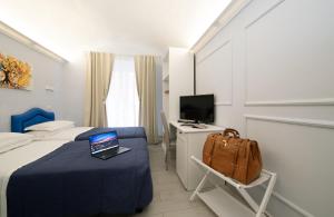 a hotel room with a laptop computer on a bed at Hotel Priscilla in Rome