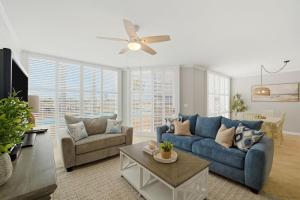 a living room with blue couches and a ceiling fan at SeaSpray Riverside 112 in Perdido Key