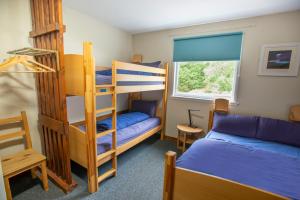 a bedroom with two bunk beds and a window at Crianlarich Youth Hostel in Crianlarich