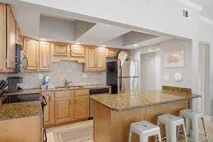 a kitchen with wooden cabinets and a counter top at SeaSpray Riverside 112 in Perdido Key