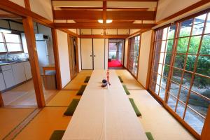 a long table in a room with large windows at YADOOR名張 -kominka- in Nabari