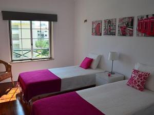 Habitación de hotel con 2 camas y ventana en Alegre Apartamento, en Cascais