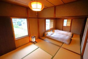 a small room with a bed and two windows at YADOOR名張 -kominka- in Nabari