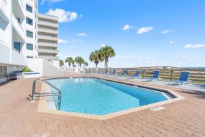 a swimming pool with chairs next to a building at SeaSpray Riverside 112 in Perdido Key