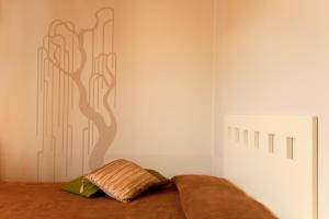 a bedroom with a bed with a tree mural on the wall at Agorà Hotel - Calamandrana in Calamandrana
