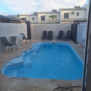 ein Swimmingpool auf einer Terrasse mit Stühlen und einem Tisch in der Unterkunft vavane in L’Étang-Salé