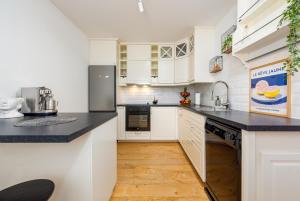 a kitchen with white cabinets and black counter tops at Holiday Home Marija with pool in Buković