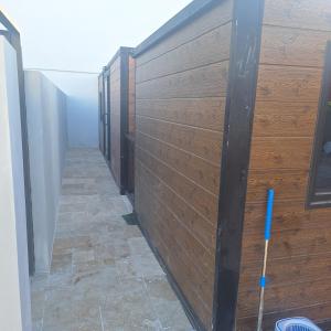 eine Reihe von Ständen in einem Raum mit einer Holzwand in der Unterkunft vavane in L’Étang-Salé