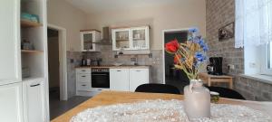 a kitchen with a table with a vase of flowers at Sandstein-Oase in Reinhardtsdorf