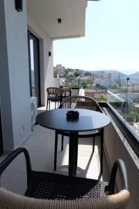 a table and chairs on a balcony with a view at Safir Luxury Suites in Sarandë