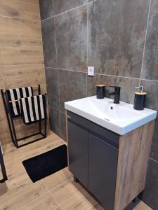 a bathroom with a white sink and a chair at Amber in Ragaciems