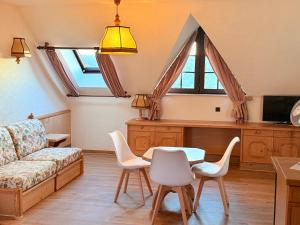 a living room with a couch and a table and chairs at In & Out Boardinghaus in Stolberg