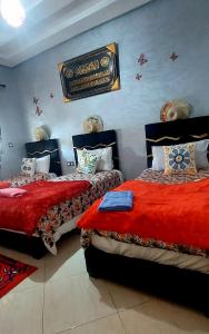 a bedroom with two beds and a sign on the wall at Apprt Ennakhil 2 in El Jadida
