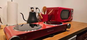 a red toaster oven sitting on a counter next to a microwave at Hibiscus Suite - Private Studio Apartment in Rhinebeck Village in Rhinebeck