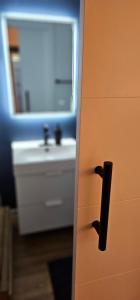 a bathroom door with a sink and a mirror at Hibiscus Suite - Private Studio Apartment in Rhinebeck Village in Rhinebeck