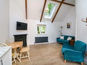 a living room with a table and chairs and a fireplace at The Mews Derrybawn in Glendarragh