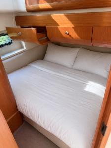 a small bed in an rv with wooden cabinets at Midnight business in Thorpe