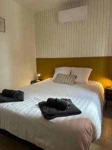 a bedroom with a bed with towels on it at Résidence le 1564 Vert in Roussillon en Isere