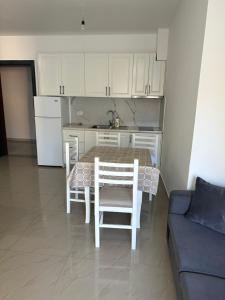 a kitchen with a table and chairs and a couch at Leo Apartments in Lezhë