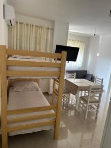 a bedroom with a bunk bed and a dining room at Leo Apartments in Lezhë